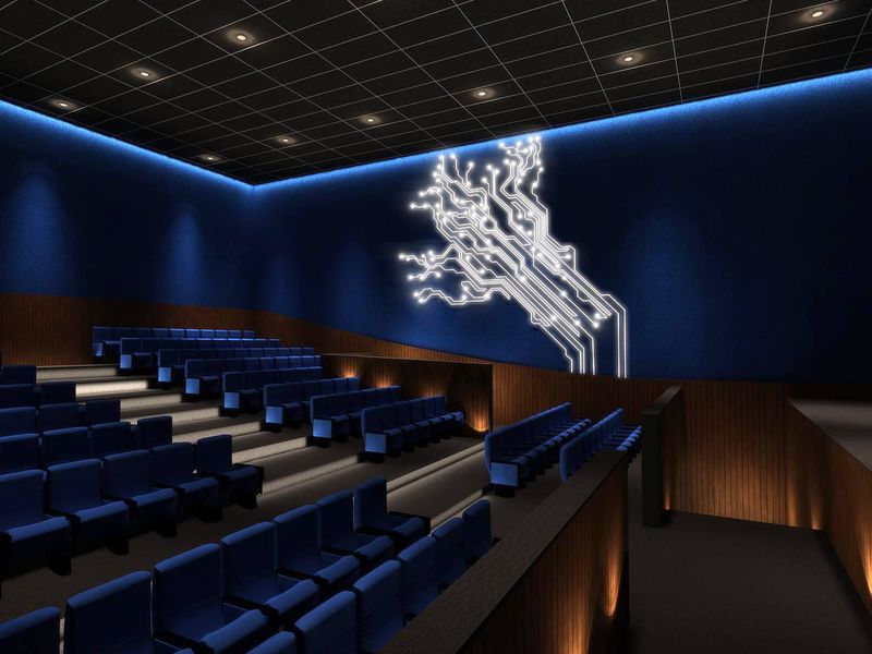 Still frame from a 3D walkthrough of a theatre interior with blue seating